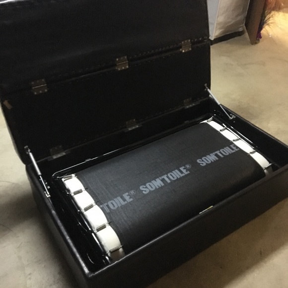 Black leather ottoman pulls out to a single bed.